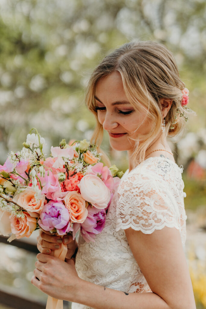 Braut mit Blick auf Kirschblütenbrautstrauß