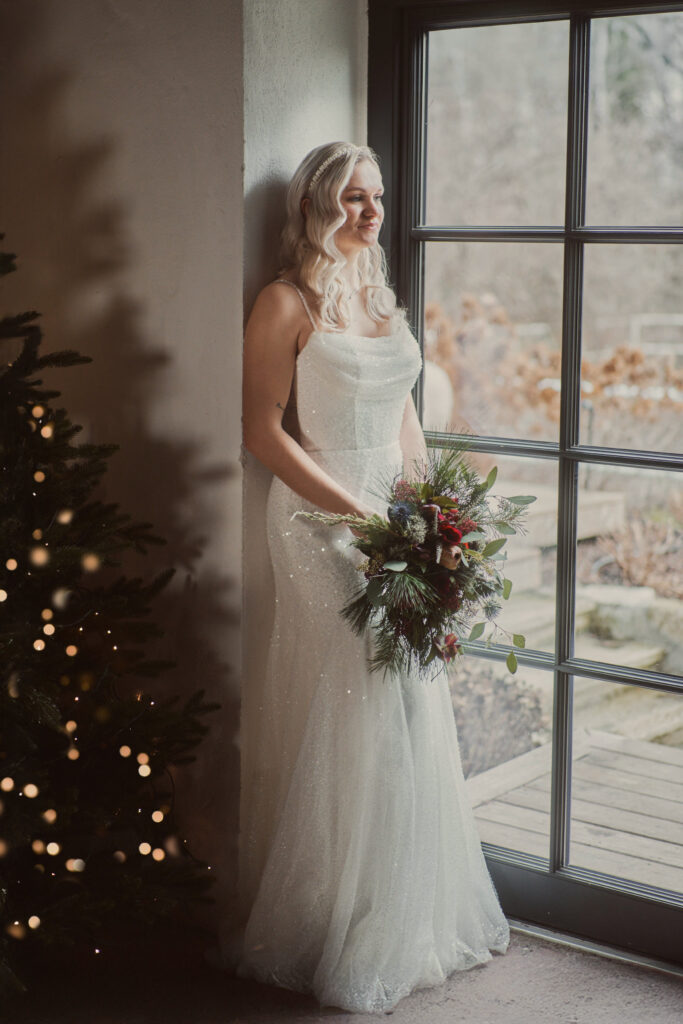 Braut mit Brautstrauß vor Christbaum
